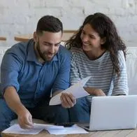 Foto de pareja contenta con cuentas, en nota de cómo hallar CDT con mejor tasa en Colombia entre Bancolombia, BBVA y más bancos