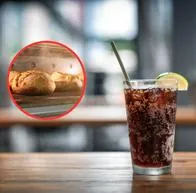 Un vaso de gaseosa y de fondo porciones de pan recién horneados