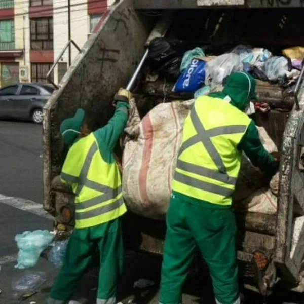 Trabajadores recolectando basura. En relación con hombre que murió al caer de camión de basuras en Bogotá.