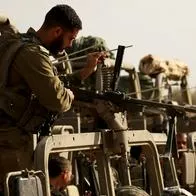 Un soldado israelí realiza trabajos de mantenimiento de su arma en un punto de reunión a lo largo de la frontera con Gaza, este martes tras regresar de la Franja de Gaza. Como parte de las 