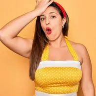 Mujer vestida de amarillo haciendo gesto de que olvidó algo.