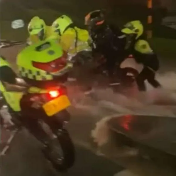 Fotos de rescate durante lluvias, en nota de policías de Bogotá salvaron a motociclista por corriente de aguacero que casi lo arrastra