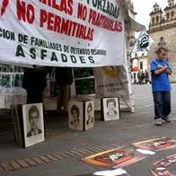 Dos jóvenes observan una exposición en la Plaza de Bolivar, en Bogotá, con cientos de fotografías de ciudadanos colombianos detenidos desaparecidos por fuerzas paramilitares, desde finales de los años 80 hasta la fecha, el 07 de abril de 2005. Segun organizaciones defensoras de los derechos de las víctimas las cifras de éstas ascienden a más de 7 mil personas.