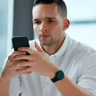 Foto de persona frente a celular, en nota de que Colpensiones anunció cambio de horario para enero y explicó desde cuándo reanudará servicio