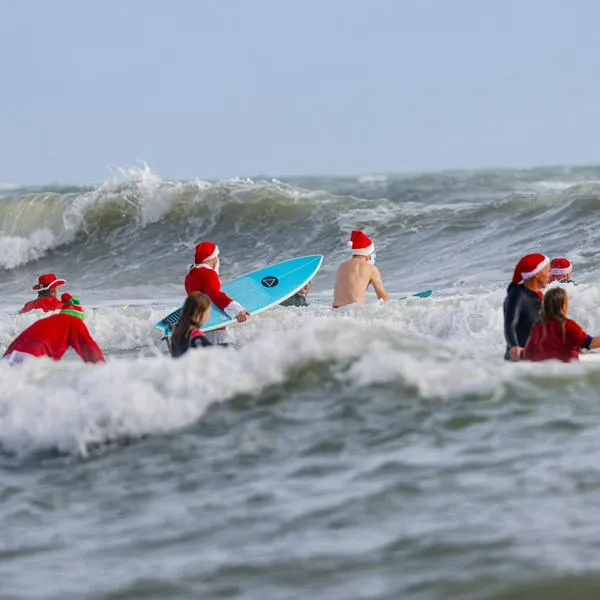 Papás Noel surfistas se toman playa de Florida por diversión y una buena causa