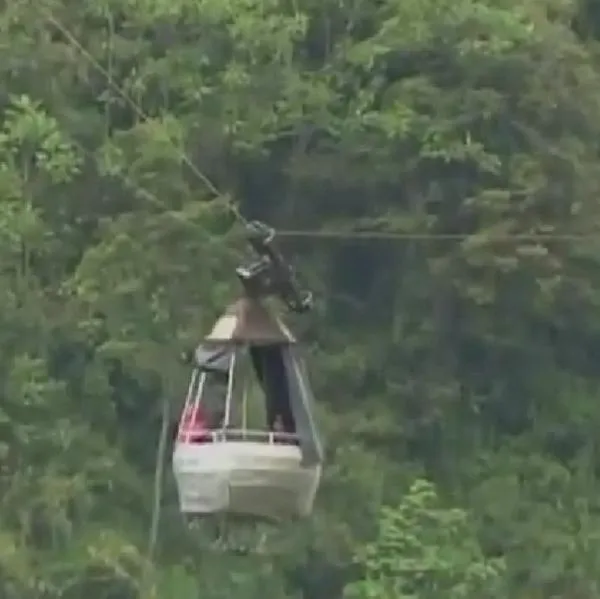 Tratan de rescatar a cinco personas atrapadas en teleférico más de 250 metros de altura.