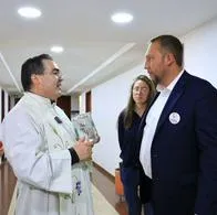 Alcalde ruso de Tunja, Mikhail Krasnov, junto al sacerdote que  roció agua bendita al edificio municipal