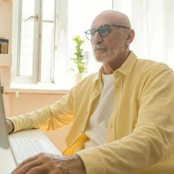 Foto de anciano frente a computador, en nota sobre si es mejor jubilarse con Colpensiones o fondos privados en Colombia, con claves para responder esa duda