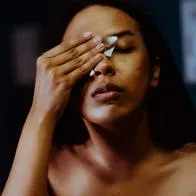 Foto de mujer limpiando su rostro, en nota de qué hace Vitamina C en la cara, por qué es recomendable y cómo usarla en la piel