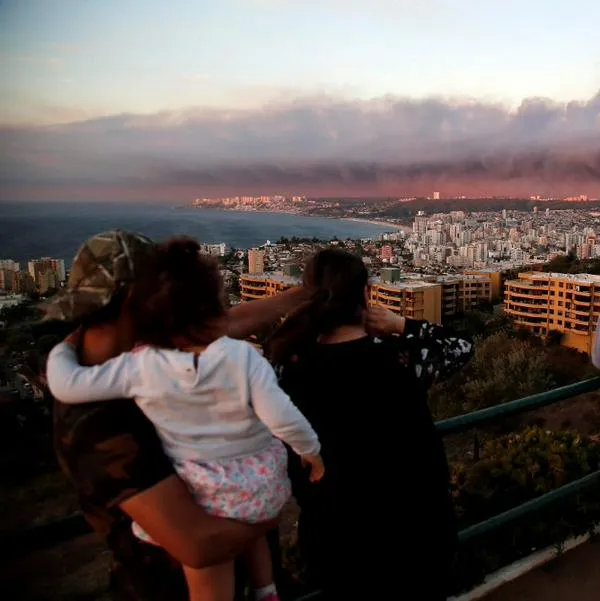 Chilenos observan densas humaredas ocasionadas por incendios forestales.