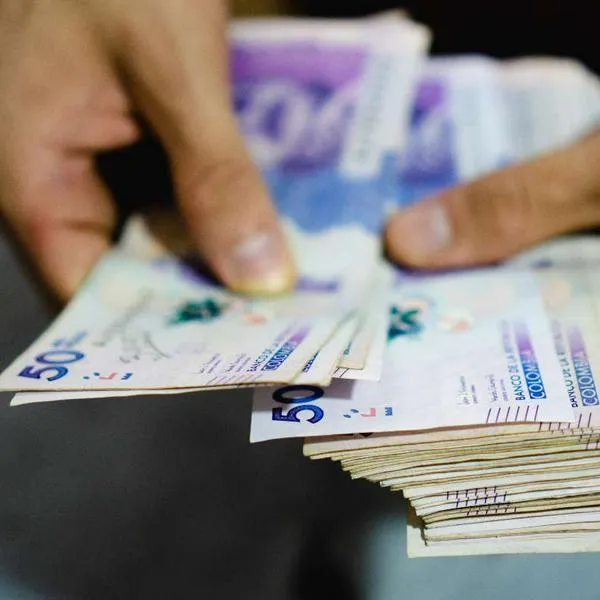 Foto de persona con billetes colombianos, en nota de cómo ganarse el Baloto y más loterías en Colombia evitando errores; consejos prácticos