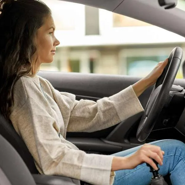 Foto de mujer manejando automóvil, en nota de cómo saber si tengo problemas en la caja de cambios del carro: estás son las señales