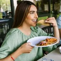 Foto de persona comiendo, en nota sobre restaurantes en Colombia y cuál vale más entre Starbucks, McDonalds, KFC, Subway y Taco Bell