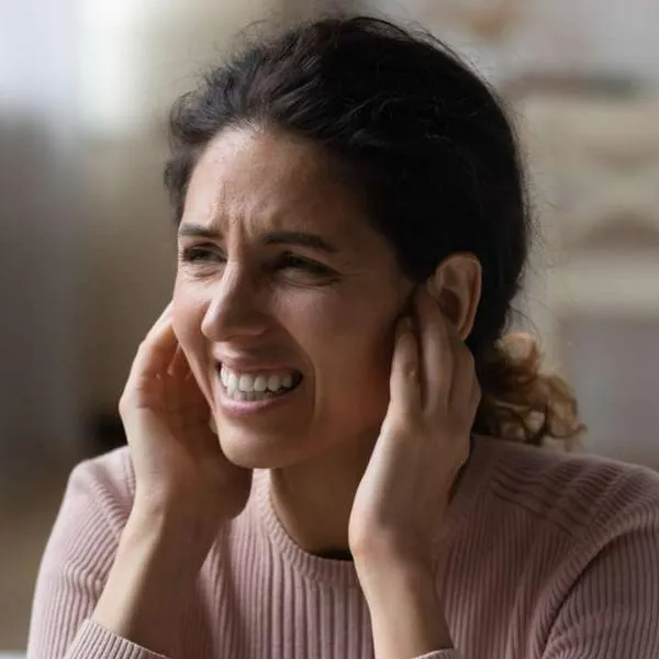 Foto de mujer con dolor, en nota de cómo se puede perder el oído por error en Colombia y cómo evitar daño en salud