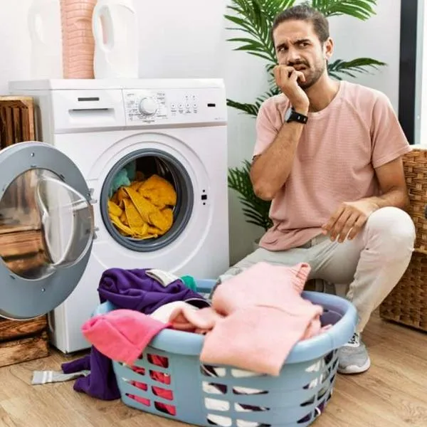 Foto de hombre con lavadora, en nota de para qué sirve el tercer compartimento de este electrodoméstico: cumple tarea poco conocida