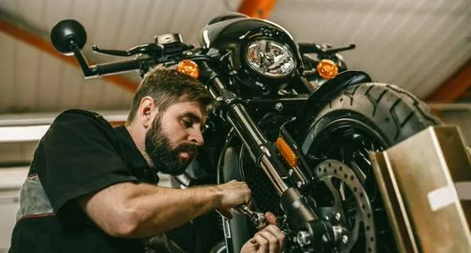 Foto de mecánico con motocicleta, en nota de a cuántos kilómetros se hace mantenimiento de una moto: así debe calcular para prevenir