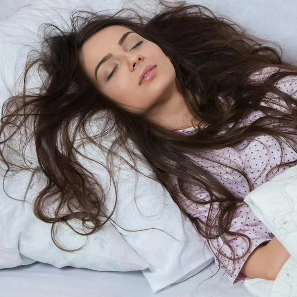 Mujer durmiendo, en nota sobre si es mejor dormir con el pelo suelto o recogido