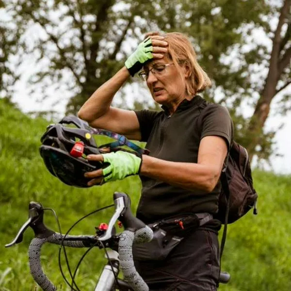 Foto de mujer con caso, en nota sobre cómo quitar el mal olor del casco de bicicleta.