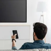 Foto de televidente, en nota de cómo puedo configurar mi televisor para ver canales de cable o satélite.