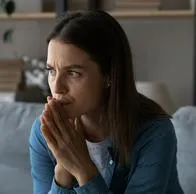 Imagen de mujer preocupada por nota sobre impuesto en Colombia