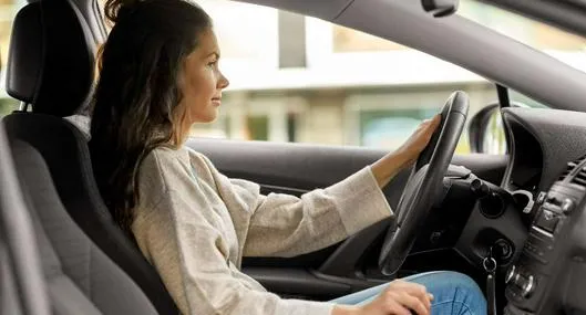 Foto de mujer conduciendo, en nota de qué significa la imagen de una llave en el tablero del carro