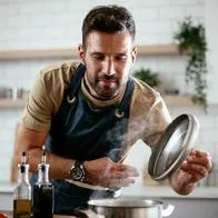 Foto de hombre cocinando, en nota sobre cómo sacar el olor a comida de la casa con trucos caseros si no se tiene extractor