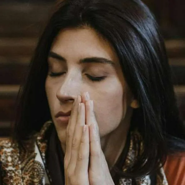 Foto de mujer rezando, en nota de cuál es la iglesia más visitada de Colombia.