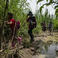 Migrantes ilegales cruzando la frontera entre Colombia y Panamá, por el Darién.