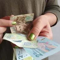 Imagen de mujer contando plata por nota sobre cambio de subsidios en Colombia