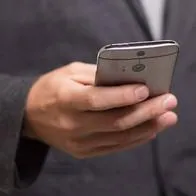 Foto de persona con celular, en nota de por qué hay números que llaman y cuelgan.