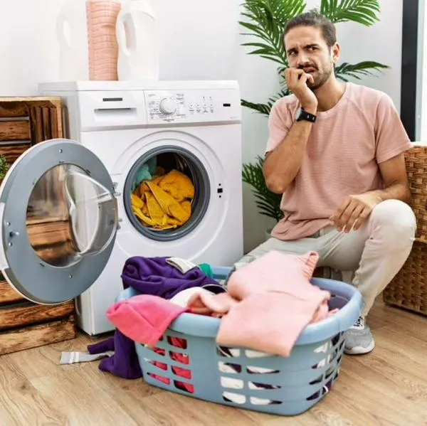 Foto de hombre lavando, en nota sobre por qué las medias desaparecen en la lavadora.