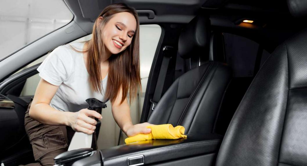 Foto de mujer limpiando automóvil, en nota de qué hacer si el carro huele mal con truco en pasos con café y bicarbonato de sodio