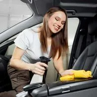 Foto de mujer limpiando automóvil, en nota de qué hacer si el carro huele mal con truco en pasos con café y bicarbonato de sodio