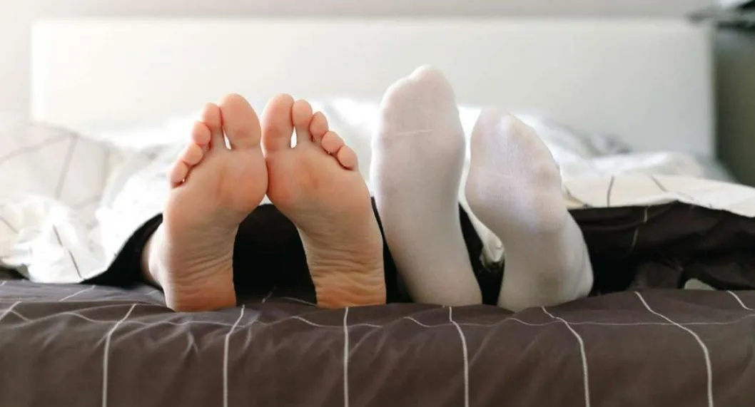 Foto de personas en cama, en nota de qué es mejor entre dormir con o sin medias: una puede causar enfermedades y más