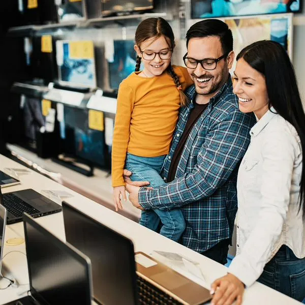 Personas mirando computadores, en nota sobre descuentos en el Éxito