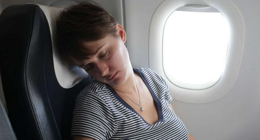 Foto de persona descansando en avión, en nota sobre cómo dormir durante un vuelo y por qué no hacerlo antes de despegar 