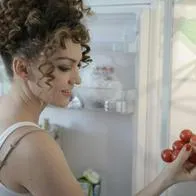 Foto de mujer con congelador, en nota sobre cuánto tiempo conectar la nevera luego de moverla para evitar daño y cómo hacerlo
