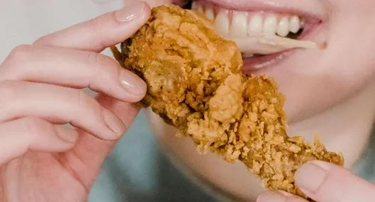 Foto de persona comiendo, en nota de qué tipo de pollo es mejor entre broaster y asado.