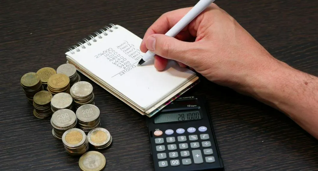 Foto de persona con dinero y calculadora, en nota de cómo invertir la prima en Colombia con planificación, pagos y gasto inteligente