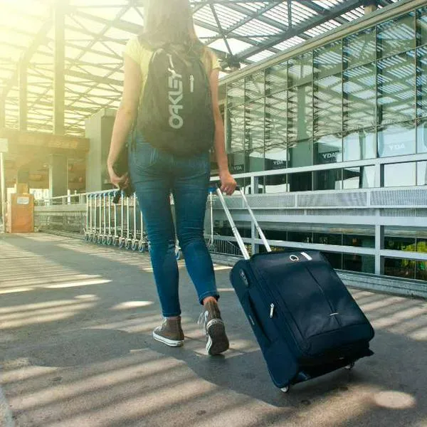 Foto de viajera, en nota de qué es más seguro entre envolver el equipaje del avión o candado 