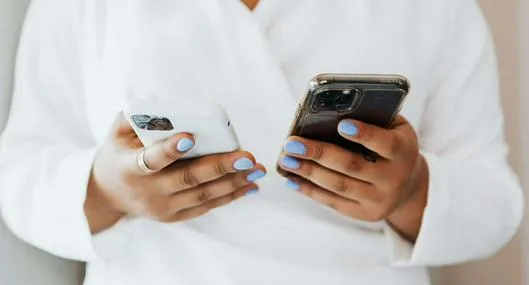Foto de persona con teléfonos, en nota de cómo limpiar correctamente la pantalla del celular