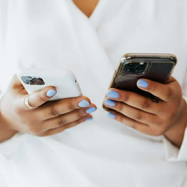 Foto de persona con teléfonos, en nota de cómo limpiar correctamente la pantalla del celular