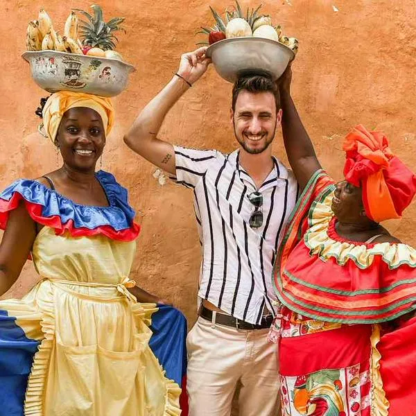 Foto de palenqueras colombianas con turista, en nota de qué significa la palabra bacano en Colombia y conozca cómo la usan otros países