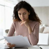 Foto de mujer con papeles, en nota sobre cómo comprar casa con crédito en el Fondo Nacional del Ahorro sin tener cesantías