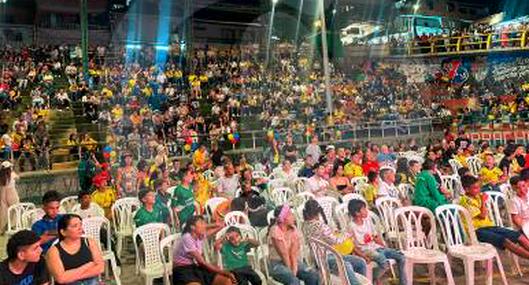 Personas viendo partido en pantalla gigante