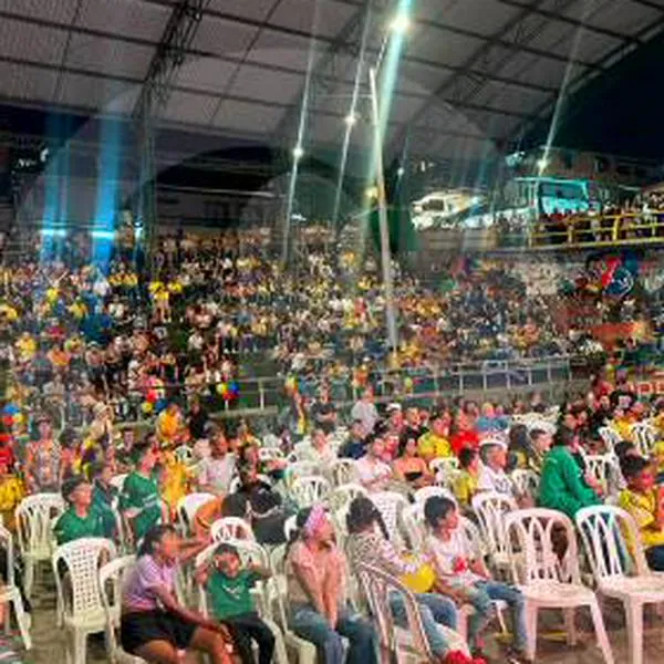 Personas viendo partido en pantalla gigante