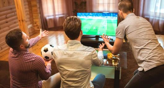 Foto de hombres viendo TV, en nota de cómo poner la TDT en televisor de Colombia para ver goles antes que los vecinos