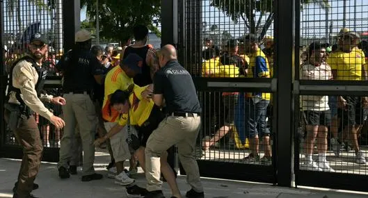 Policía capturando a hinchas colombianos que se quieren colar.