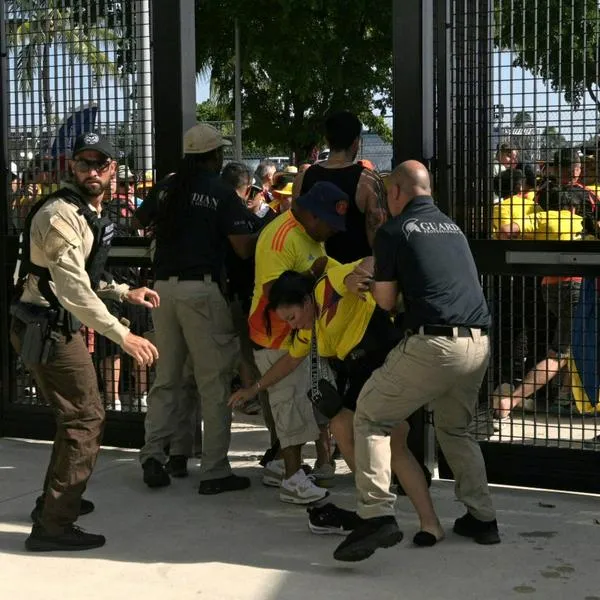 Policía capturando a hinchas colombianos que se quieren colar.