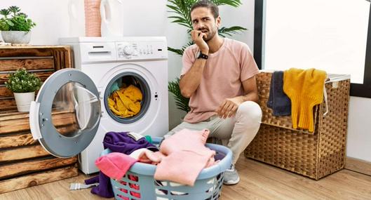 Foto de hombre con lavadora, en nota de cómo gastar menos con la lavadora para aprovechar el agua y ahorrar en el recibo